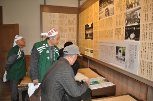 旧寮舎展示室のCD音響装置で寮歌を聴くOBら