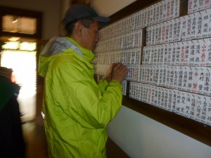 逝去会員の名札を赤札にする中島館長